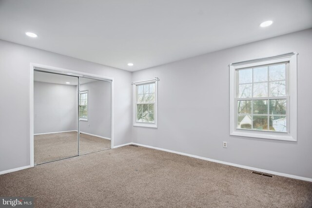 unfurnished bedroom featuring carpet floors and a closet