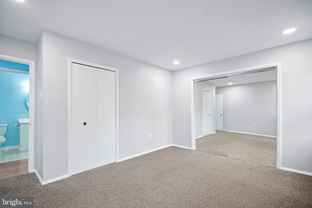 unfurnished bedroom with carpet flooring and connected bathroom