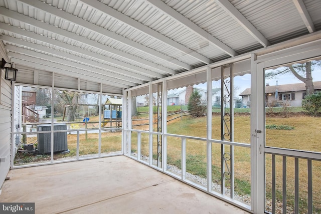 unfurnished sunroom with beamed ceiling and a healthy amount of sunlight