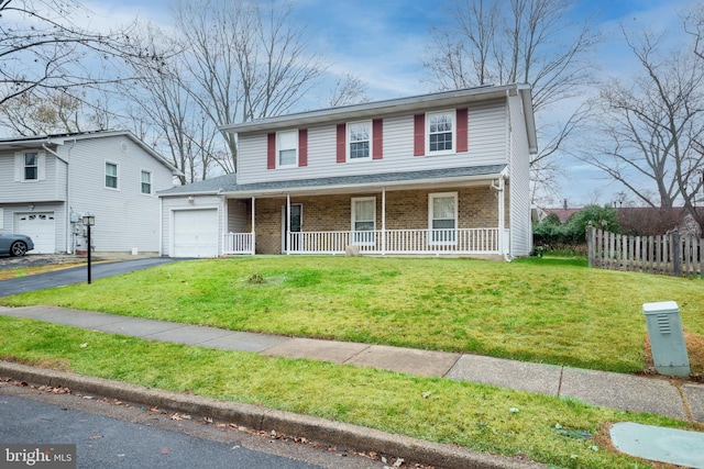 view of front of home featuring a front yard, a porch, and a garage