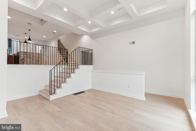 stairway with hardwood / wood-style floors, beam ceiling, and coffered ceiling