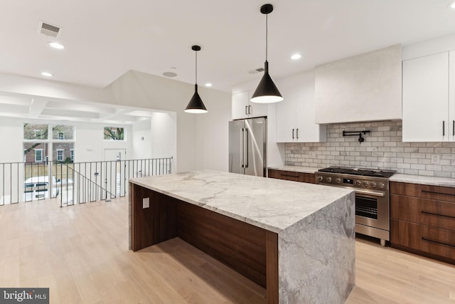 kitchen featuring white cabinetry, high quality appliances, light hardwood / wood-style flooring, and hanging light fixtures