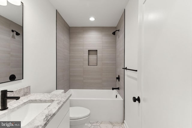 full bathroom with vanity, tiled shower / bath combo, and toilet