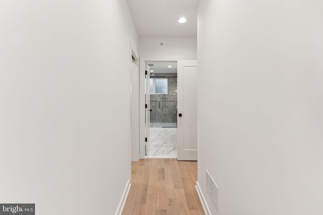 hallway with light hardwood / wood-style floors