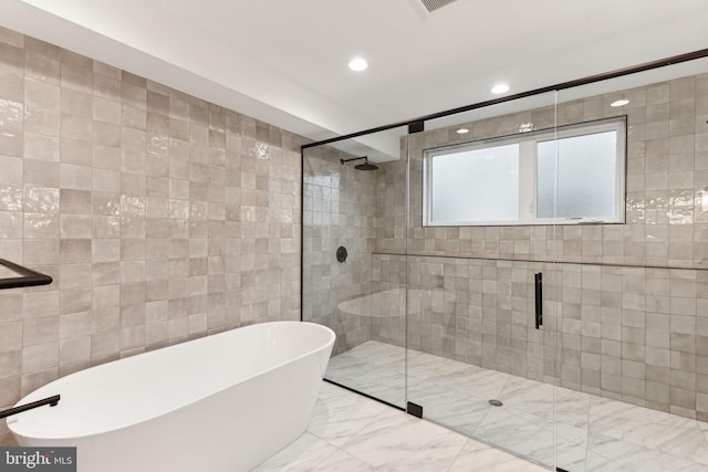 bathroom with separate shower and tub and tile walls