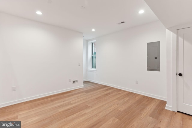 unfurnished room with light wood-type flooring and electric panel