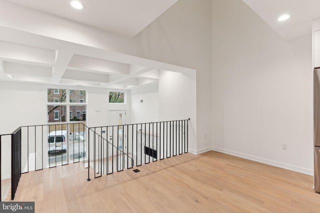 unfurnished room featuring beamed ceiling, wood-type flooring, and coffered ceiling