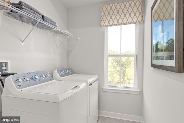 clothes washing area featuring light tile patterned flooring and washing machine and clothes dryer