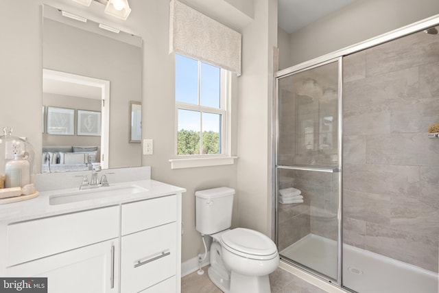 bathroom with tile patterned floors, vanity, an enclosed shower, and toilet