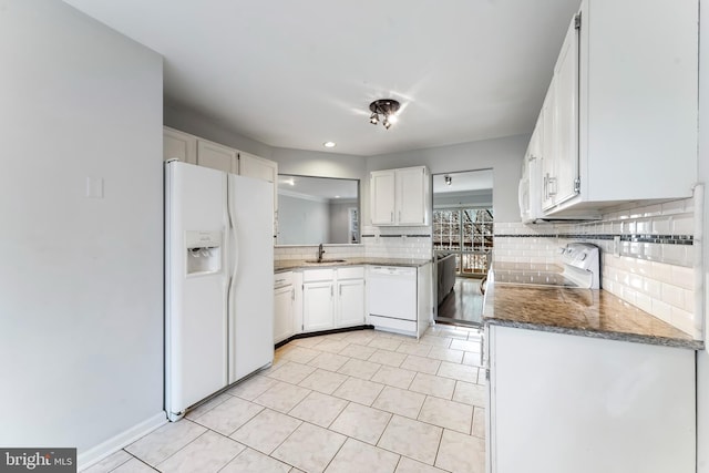 kitchen featuring sink, dark stone countertops, white appliances, decorative backsplash, and white cabinets