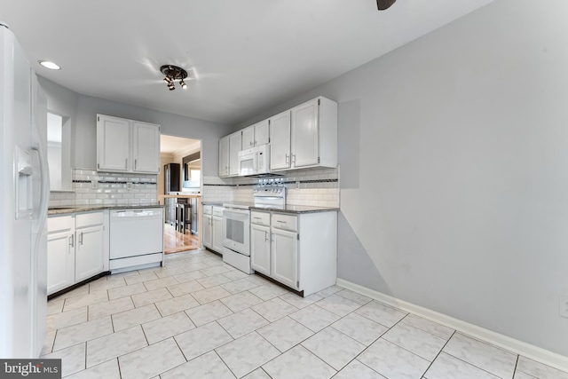 kitchen featuring white appliances, tasteful backsplash, white cabinetry, and plenty of natural light