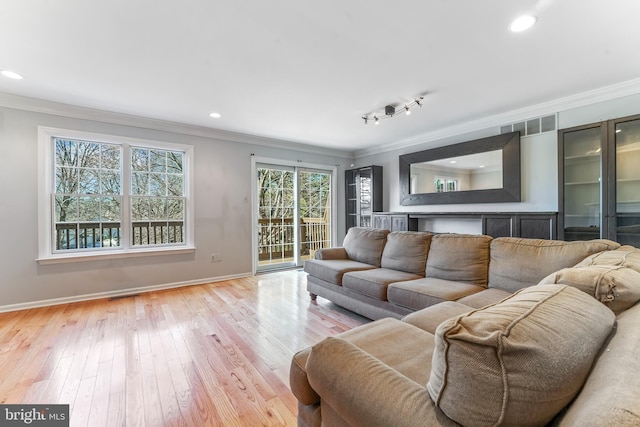 living room with light wood-type flooring and ornamental molding