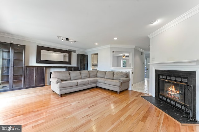 living room featuring ceiling fan, crown molding, and light hardwood / wood-style flooring