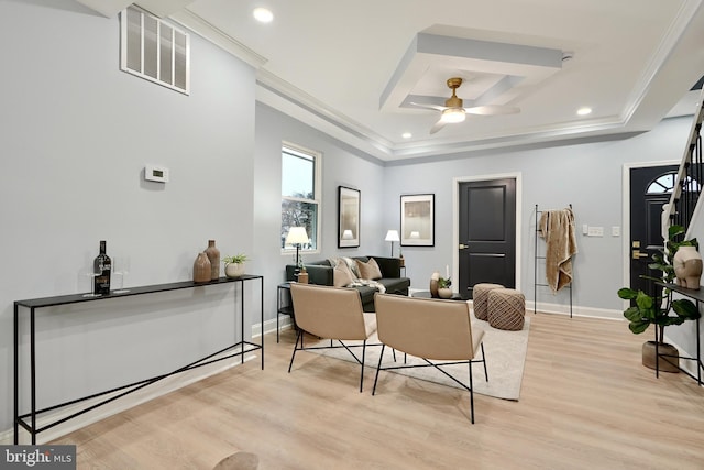 living room with light hardwood / wood-style floors, crown molding, ceiling fan, and a tray ceiling