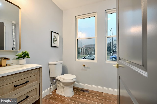 bathroom with wood-type flooring, vanity, and toilet