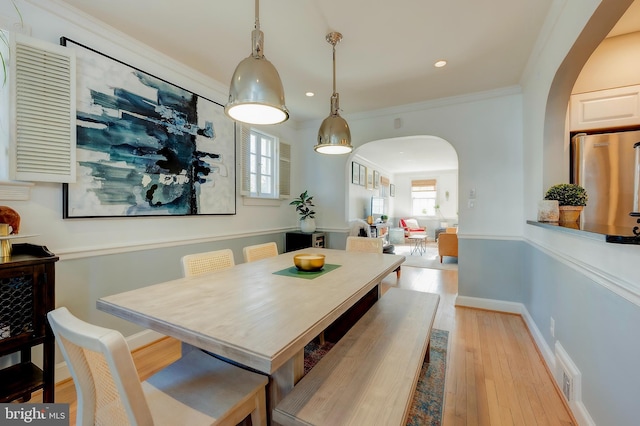 dining area with light hardwood / wood-style flooring, ornamental molding, and plenty of natural light