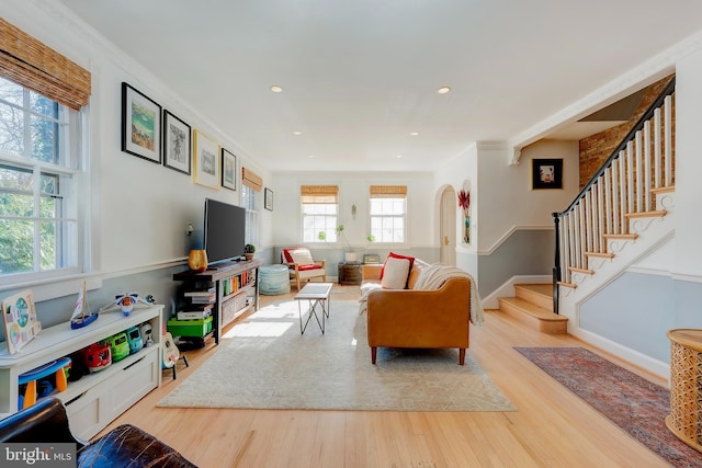 living room with crown molding and light hardwood / wood-style flooring