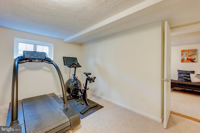 exercise area with carpet floors and a textured ceiling