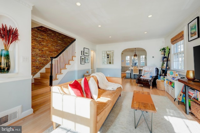 living room with light hardwood / wood-style flooring and ornamental molding