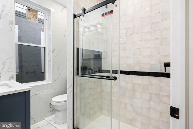 bathroom featuring vanity, toilet, walk in shower, and tile walls