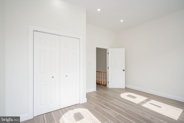 unfurnished bedroom featuring light hardwood / wood-style flooring and a closet