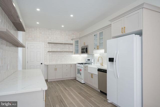 kitchen featuring sink, white cabinets, light hardwood / wood-style flooring, and appliances with stainless steel finishes