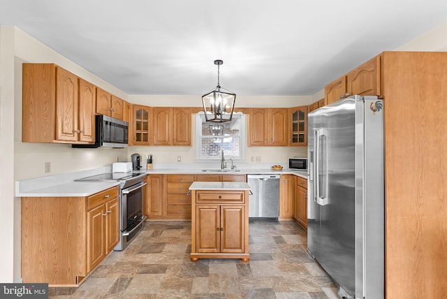 kitchen with a kitchen island, appliances with stainless steel finishes, decorative light fixtures, sink, and a notable chandelier