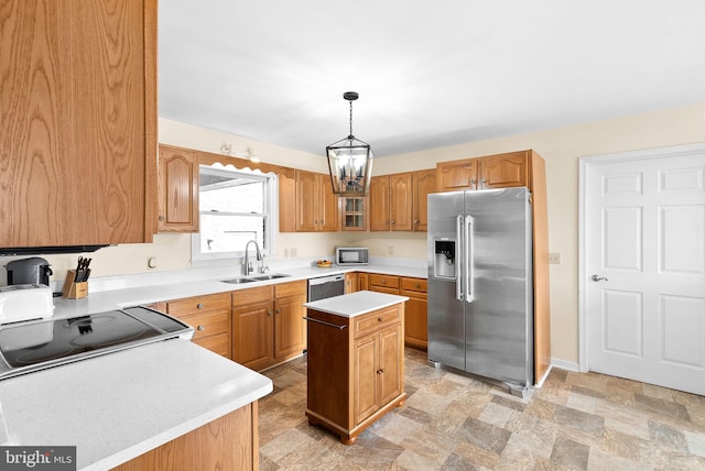 kitchen with a kitchen island, appliances with stainless steel finishes, sink, a chandelier, and hanging light fixtures