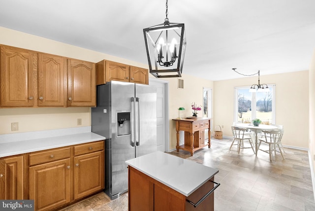 kitchen with a kitchen island, decorative light fixtures, a chandelier, and stainless steel fridge with ice dispenser