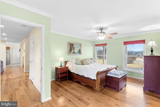 bedroom with crown molding, light hardwood / wood-style flooring, stainless steel fridge, and ceiling fan