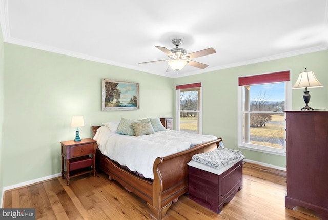 bedroom with ceiling fan, ornamental molding, and light hardwood / wood-style flooring