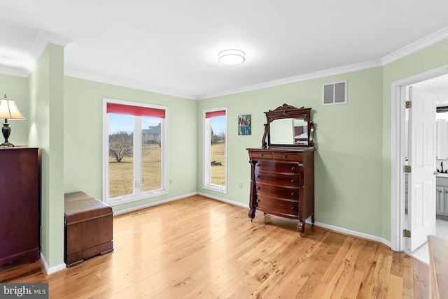 sitting room with crown molding and light wood-type flooring