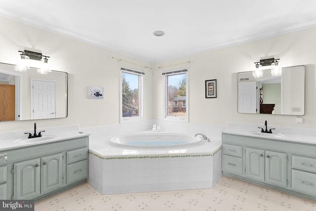 bathroom featuring vanity and tiled tub