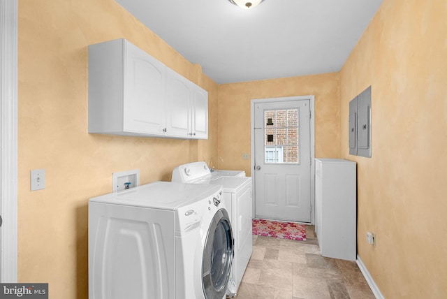 clothes washing area with separate washer and dryer, electric panel, and cabinets