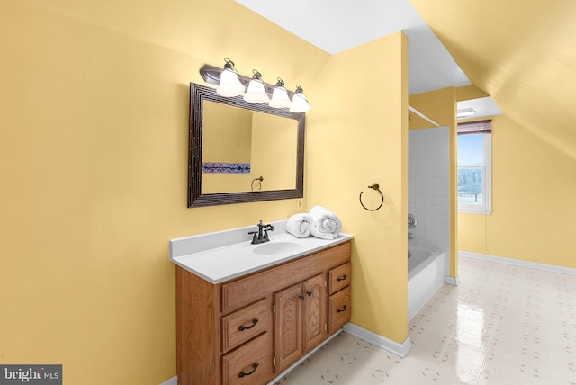 bathroom featuring bathing tub / shower combination, lofted ceiling, and vanity