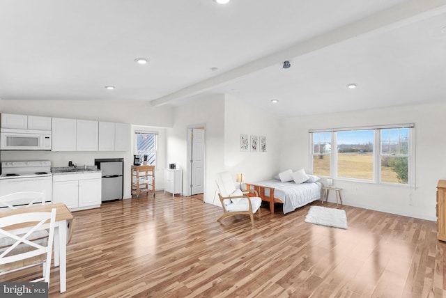 bedroom featuring fridge, sink, lofted ceiling with beams, and light hardwood / wood-style flooring