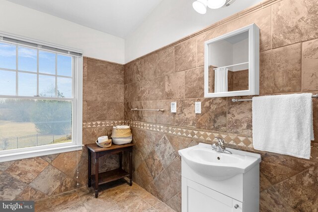 bathroom featuring vanity, tile walls, and curtained shower