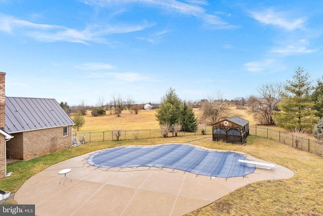 view of swimming pool with a gazebo, a patio, a lawn, and a rural view