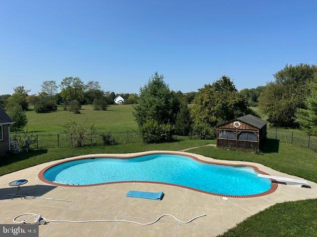 view of pool with a gazebo, a lawn, a diving board, and a patio area