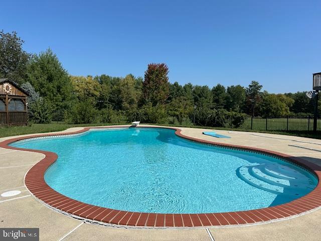 view of swimming pool with a gazebo, a diving board, and a patio area