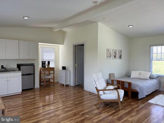 bedroom with fridge, lofted ceiling with beams, and dark hardwood / wood-style floors