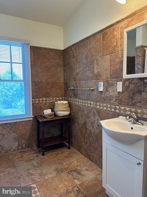 bathroom featuring tile walls, vanity, and a wealth of natural light