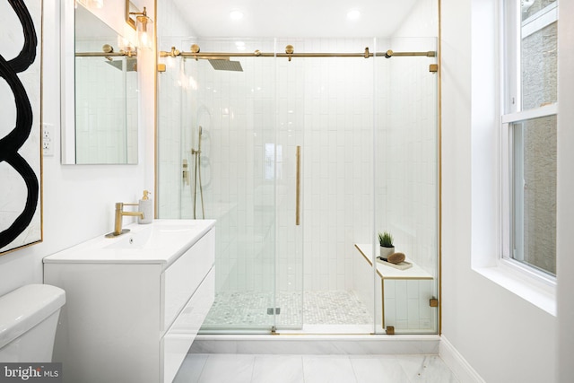 bathroom featuring a shower with door, vanity, and toilet