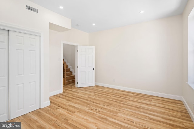 unfurnished bedroom with a closet and light hardwood / wood-style floors