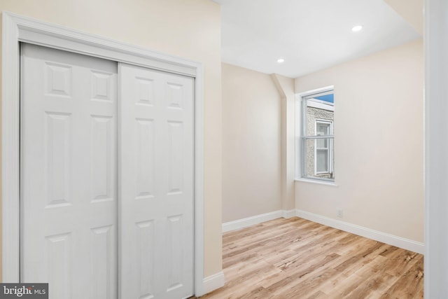 unfurnished bedroom with a closet and light hardwood / wood-style floors