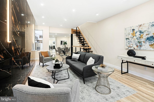 living room featuring a high end fireplace and light hardwood / wood-style floors