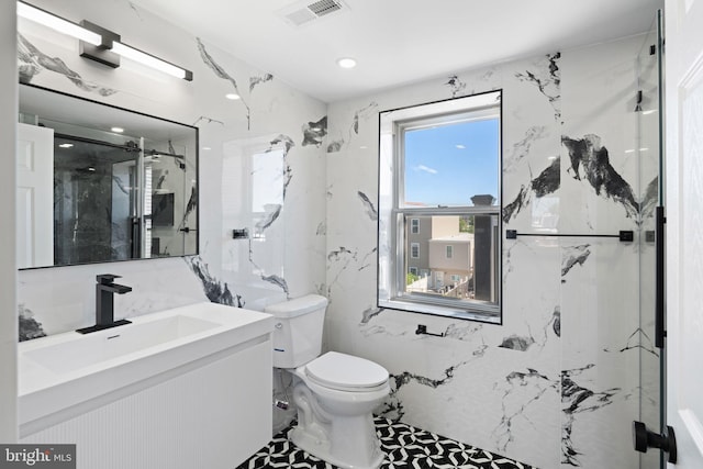 bathroom with vanity, toilet, a shower with door, and tile walls