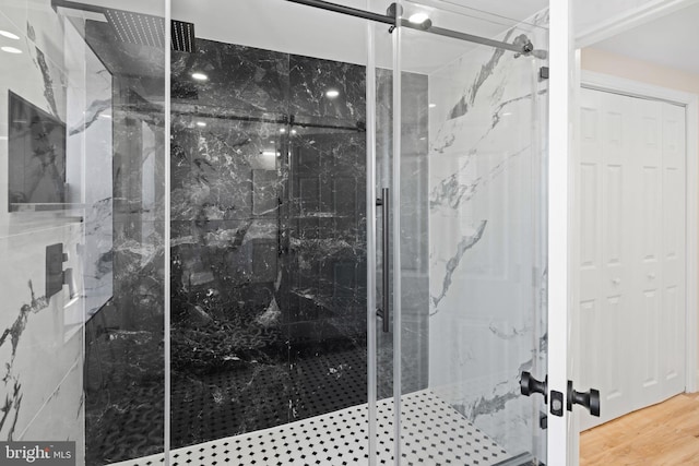 bathroom featuring hardwood / wood-style floors and a shower with door