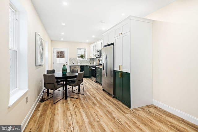 kitchen with white cabinets, light hardwood / wood-style floors, and appliances with stainless steel finishes