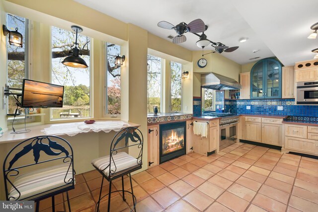 12330 Potomac View Rd, Newburg, MD 20664 - kitchen with light brown cabinetry, wine cooler, wall chimney range hood, stainless steel appliances, and tasteful backsplash